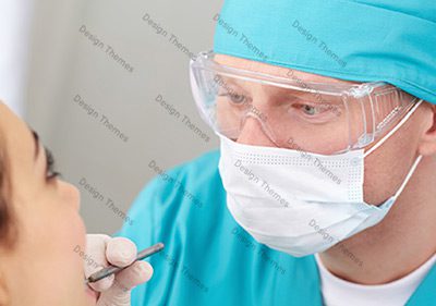 A surgeon looking at the camera while holding a pen.