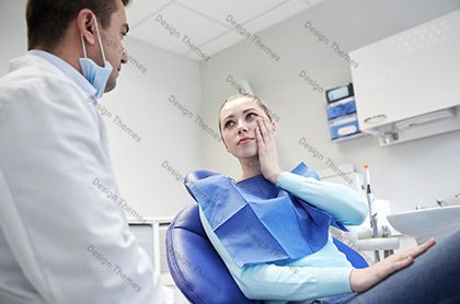 A woman sitting in front of a dentist.