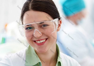 A woman wearing safety glasses and smiling.