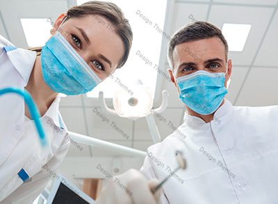Two people wearing masks and holding a toothbrush