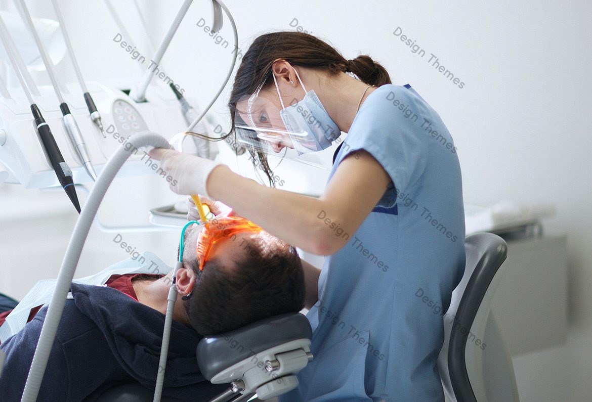 A dentist is working on the teeth of a patient.