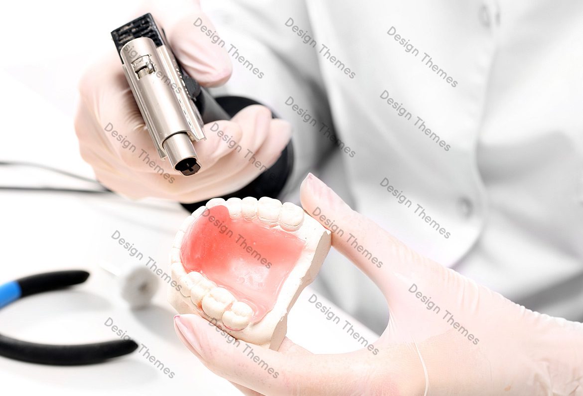 A person holding an electric razor and a tooth model.