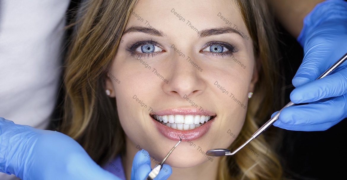 A woman getting her teeth cleaned by a dentist.