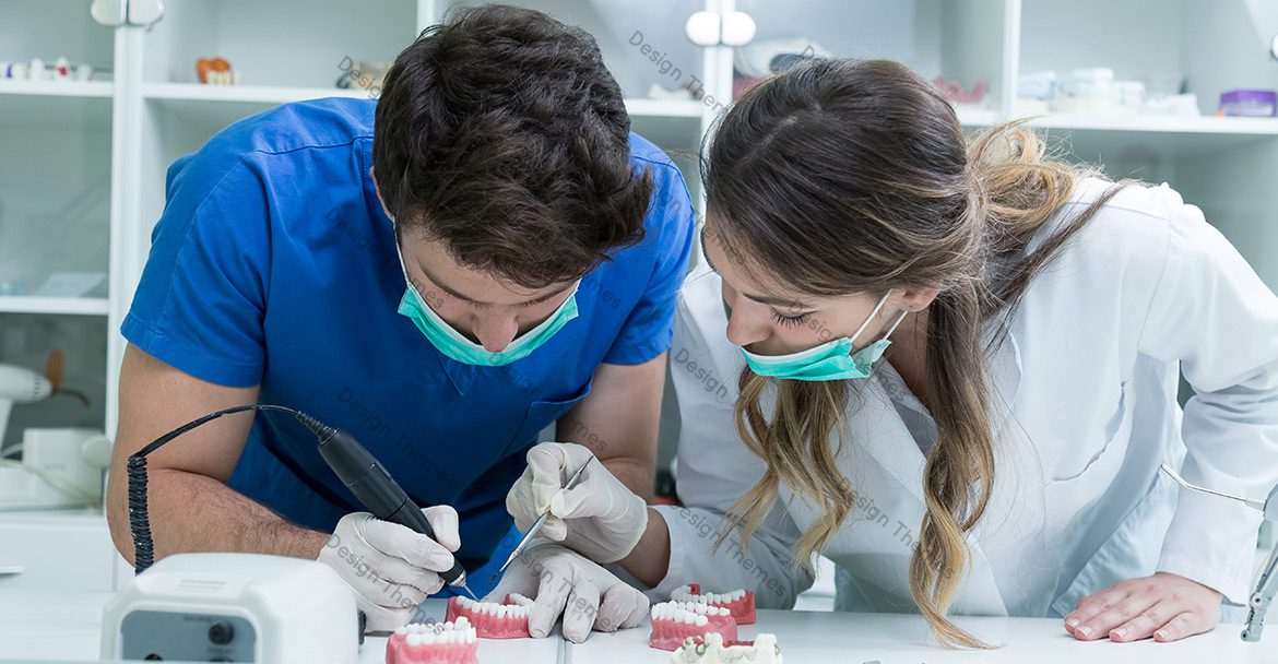 Two people in a dental lab working on teeth.
