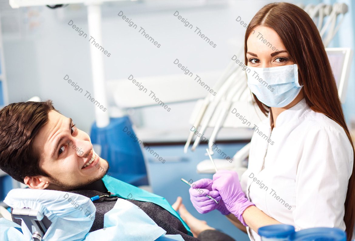 A woman in a dentist 's chair with another person.