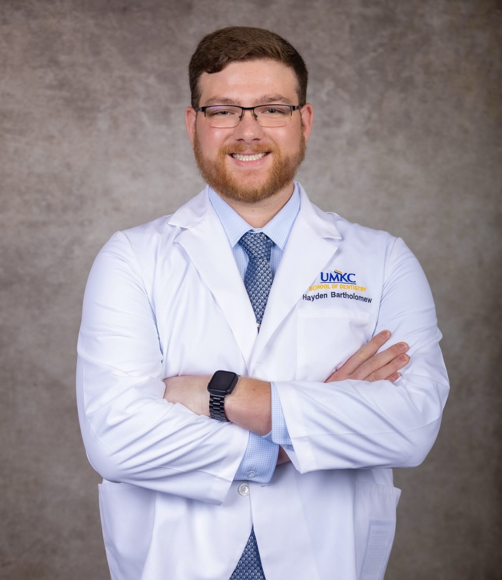 Smiling doctor in white coat with crossed arms